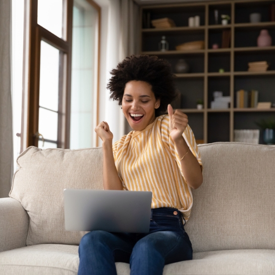 Woman sitting on couch using laptop