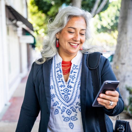 Woman walking outside looking at cell phone