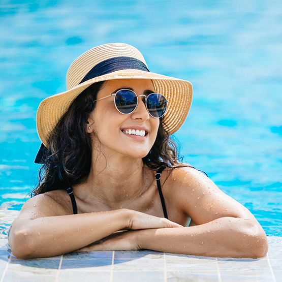 woman with hat poolside