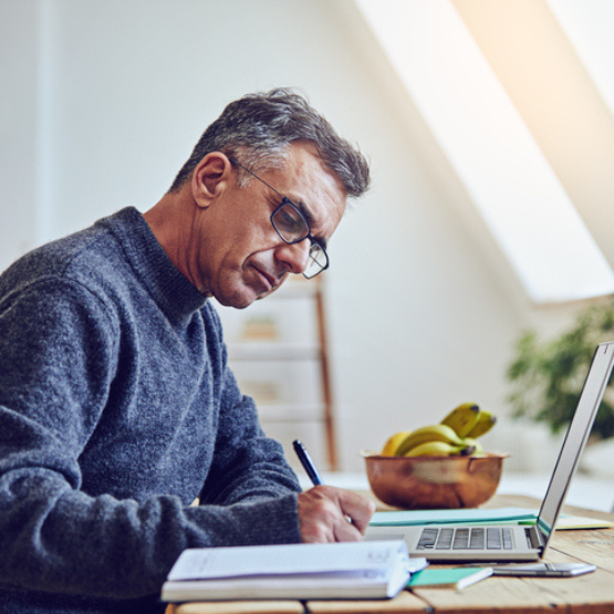 Person with laptop writing work notes