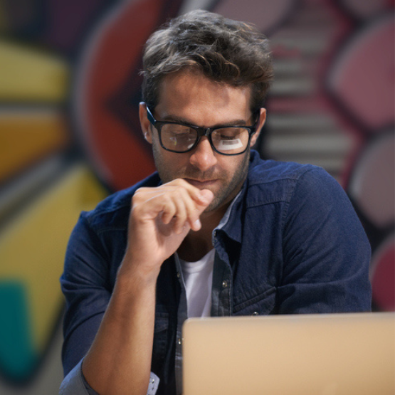 Man with glasses looking at laptop